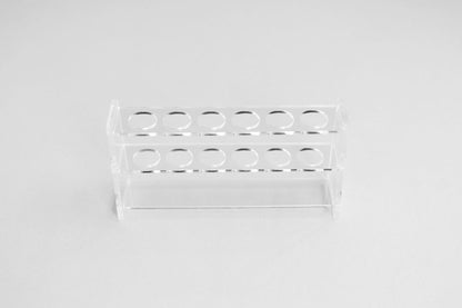 An acrylic display stand by itself on white with 6 holes to display essential oil roller bottles, lip gloss, or make up brushes
