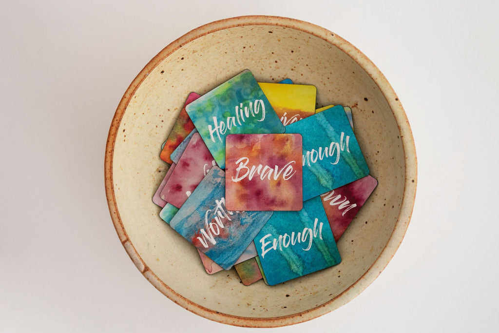 A pottery bowl filled with watercolor mini affirmation magnets