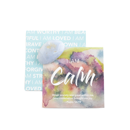 A watercolor affirmation card with scripture that says I Am Calm with a pocket stone of blue lace agate and the backside of another card on a white background