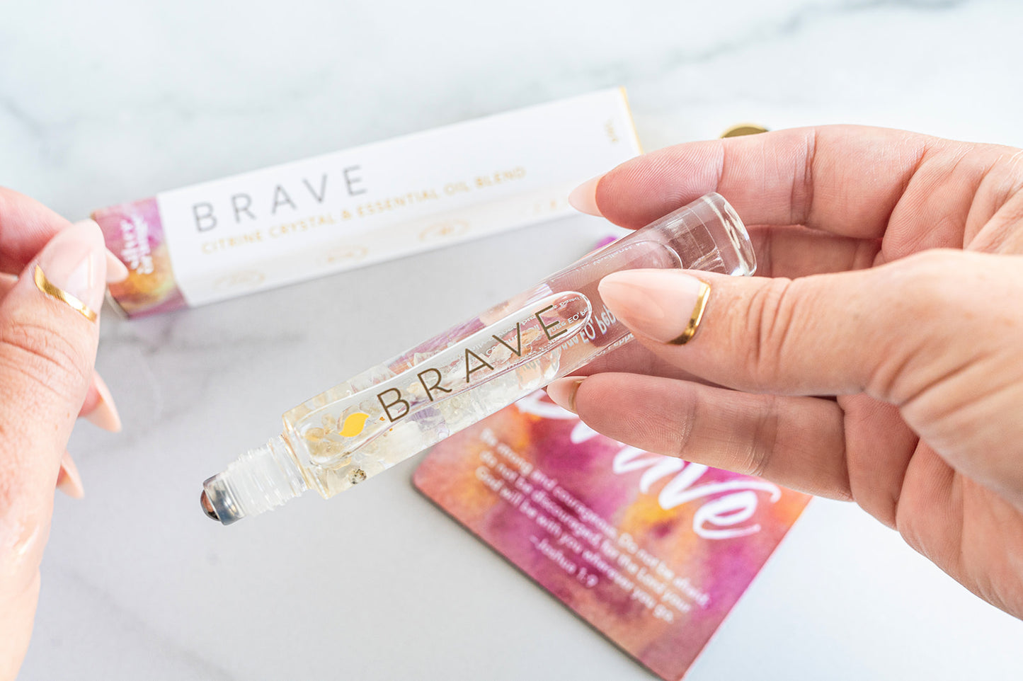 Person holding a 'Brave' skincare product with packaging in the background