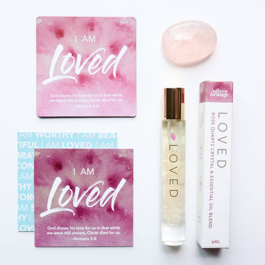Product set with 'I AM Loved' packaging and a rollerball on a white background