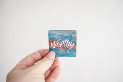 a hand holding a mini affirmation magnet that says worthy
