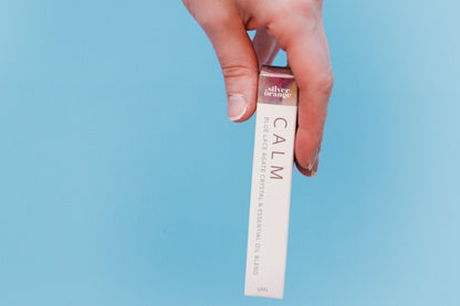Hand holding a product with 'Calm' text against a light blue background