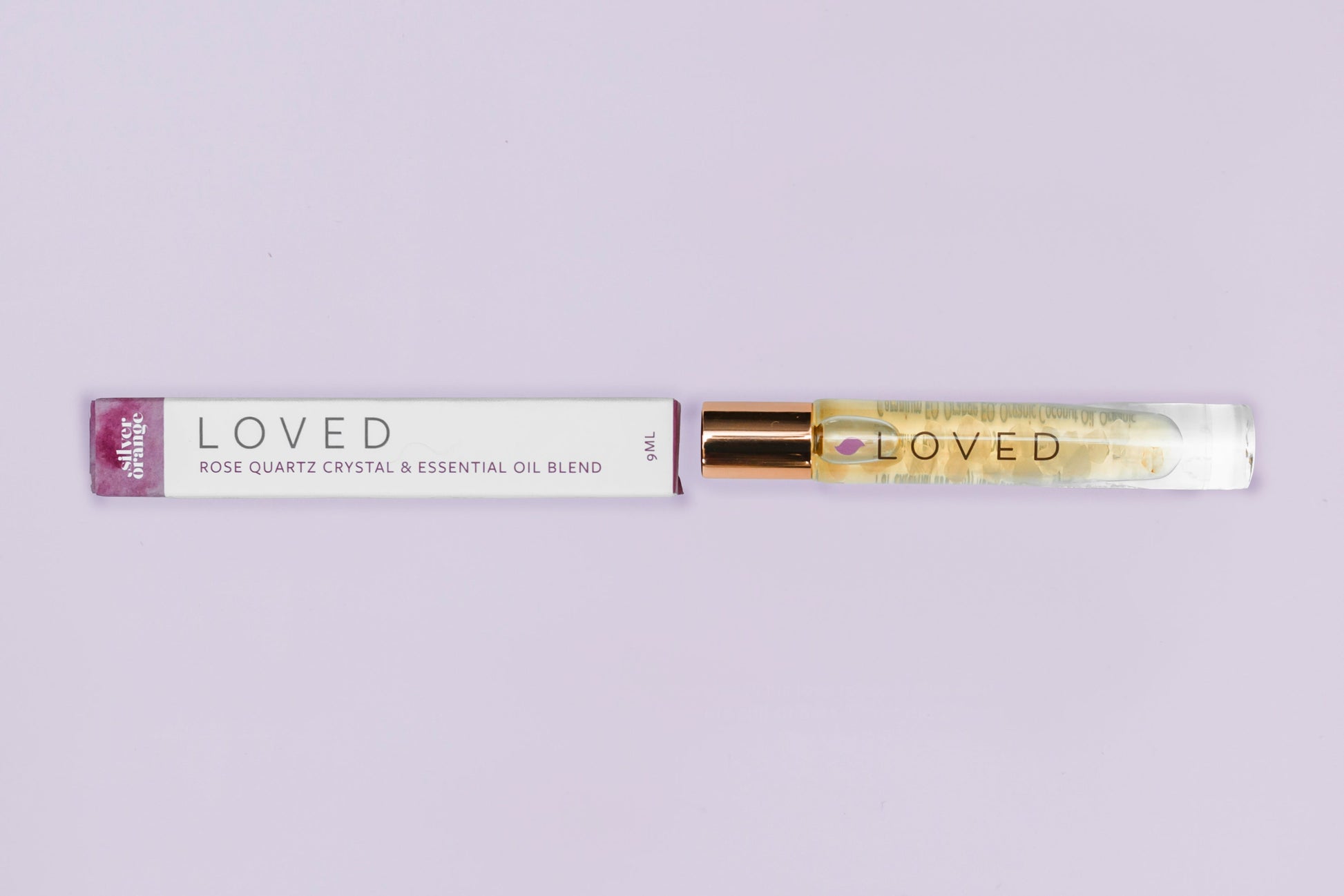Roll-on bottle labeled 'LOVED' with a purple cap on a light gray background